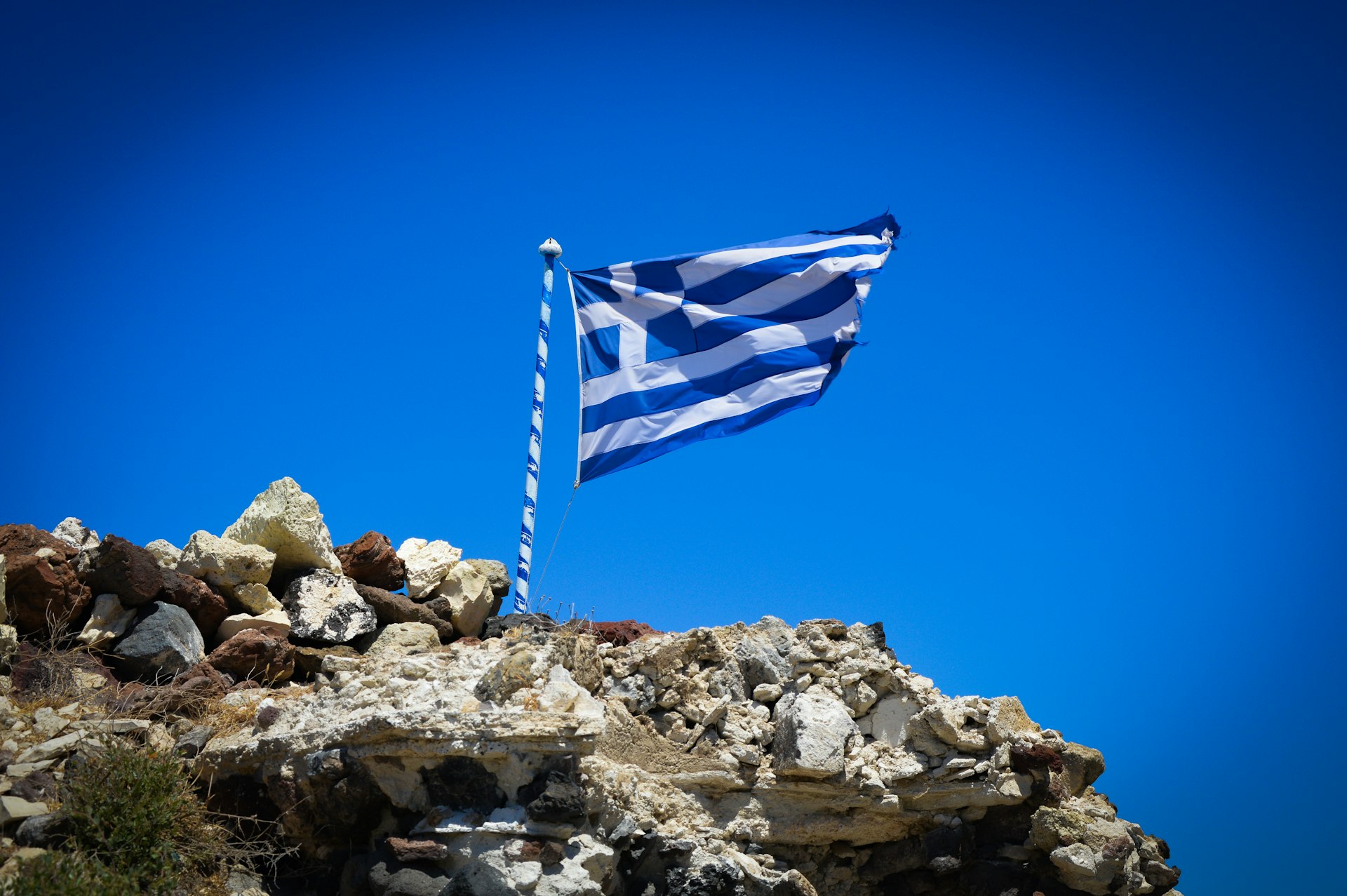 a flag flying on top of a rocky hill